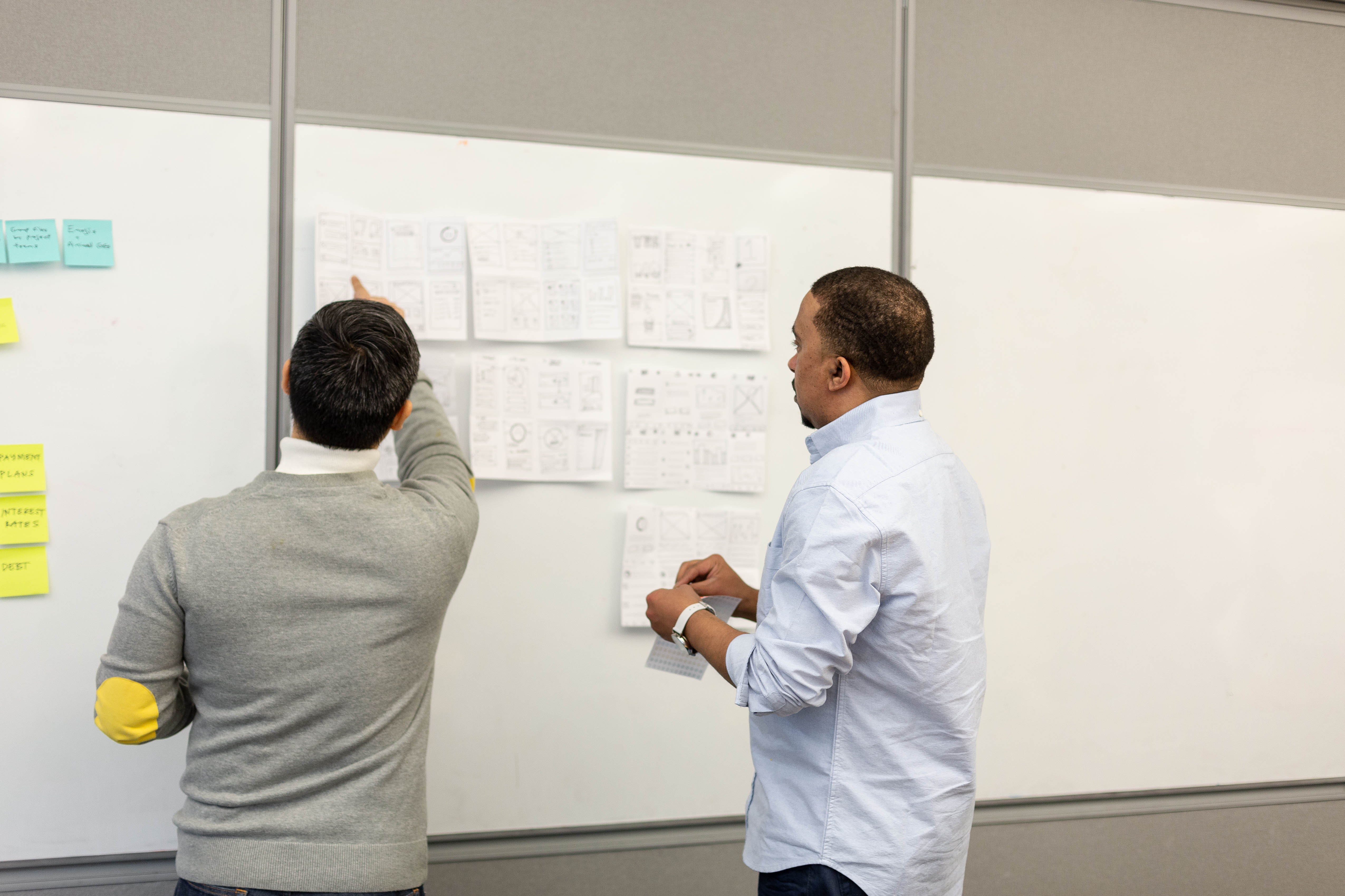 Wireframe sketches pinned across a studio wall