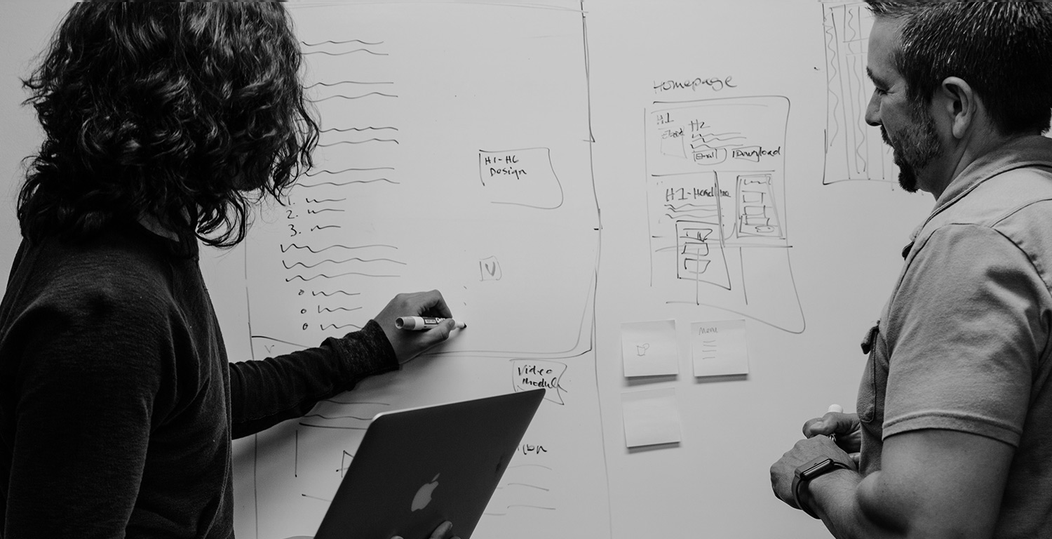 Two people collaborating on whiteboard